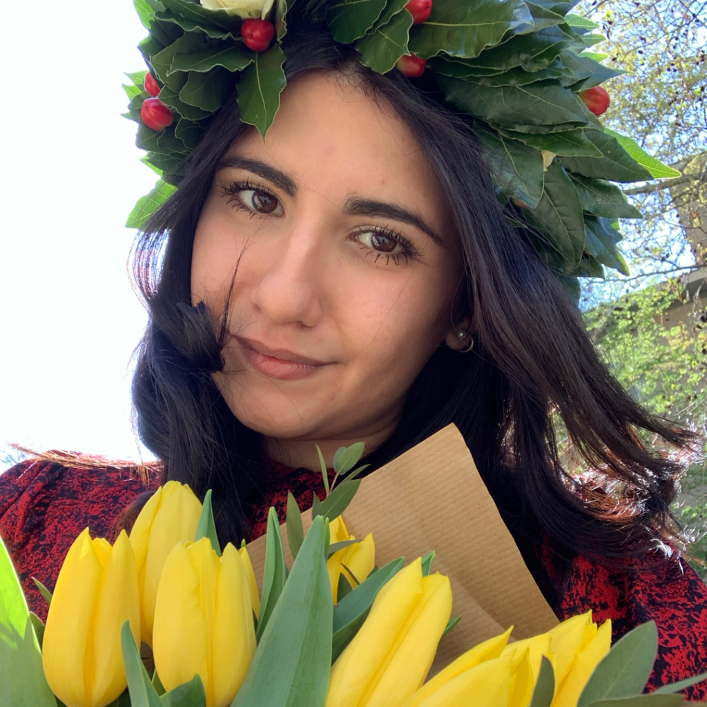Primo piano di Ilenia Aloisio con corona di alloro in testa e mazzo di fiori in mano