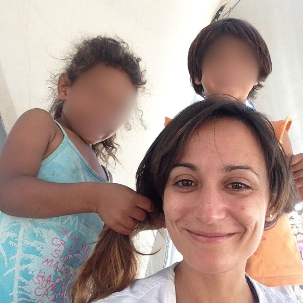 Francesca Dambruoso sorridente in primo piano insieme a due bambini durante una missione per Medici Senza Frontiere