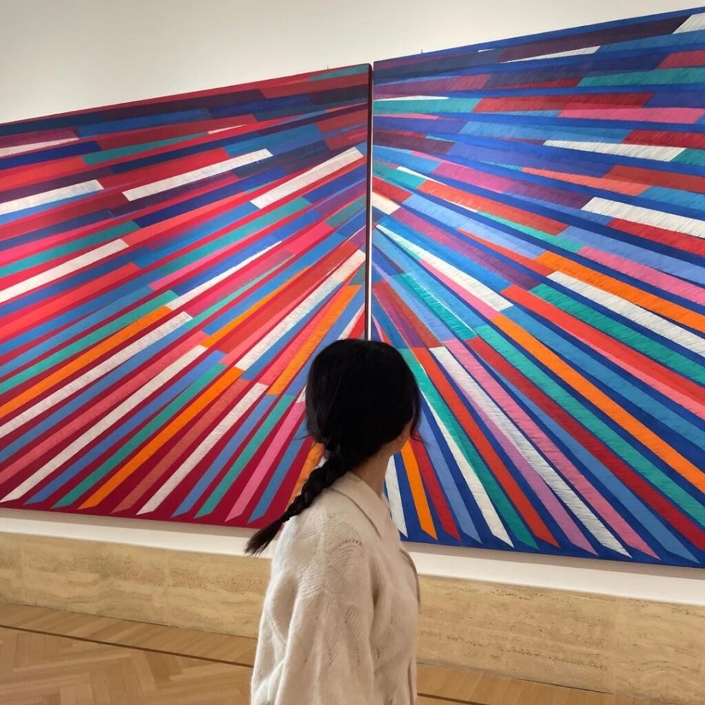 Alessia Rodighiero posa in piedi davanti a un'opera d'arte.