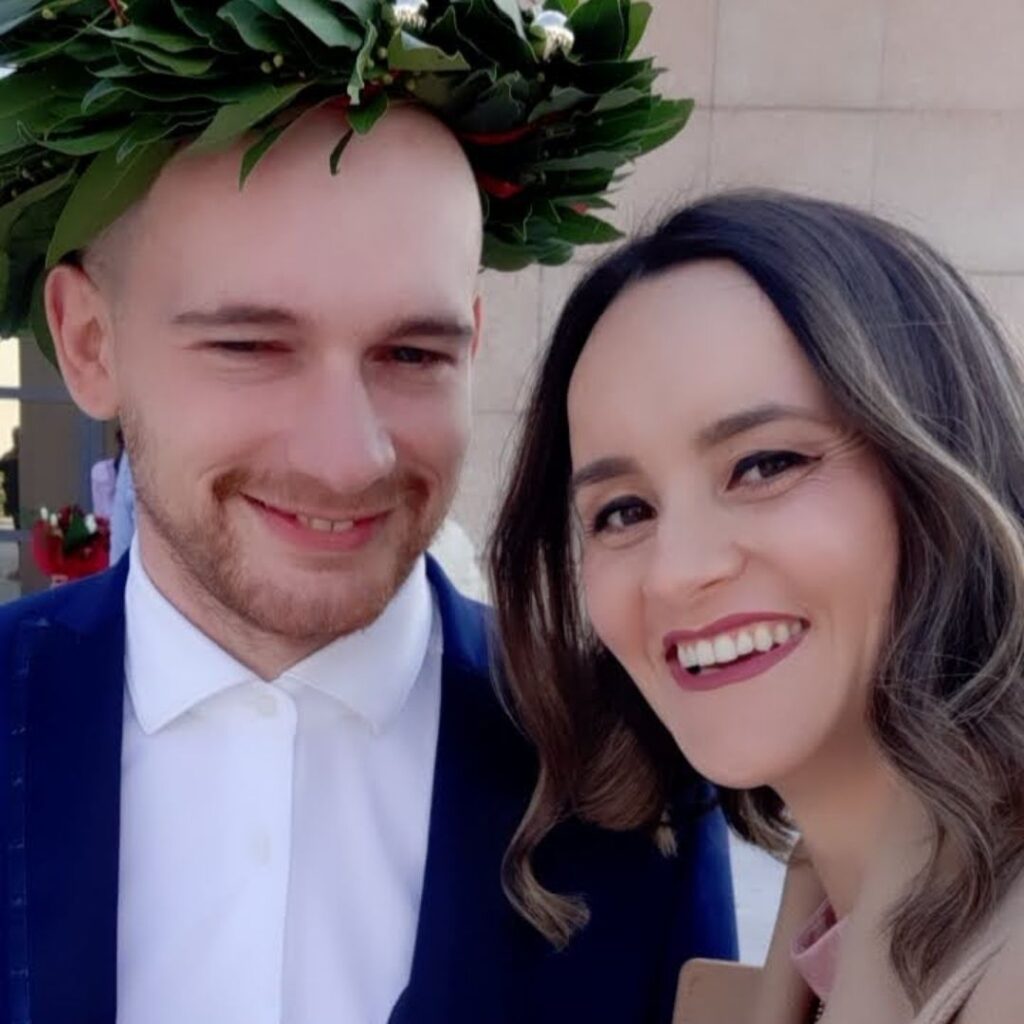 Simone Perin con corona d'alloro in testa posa accanto a una ragazza.