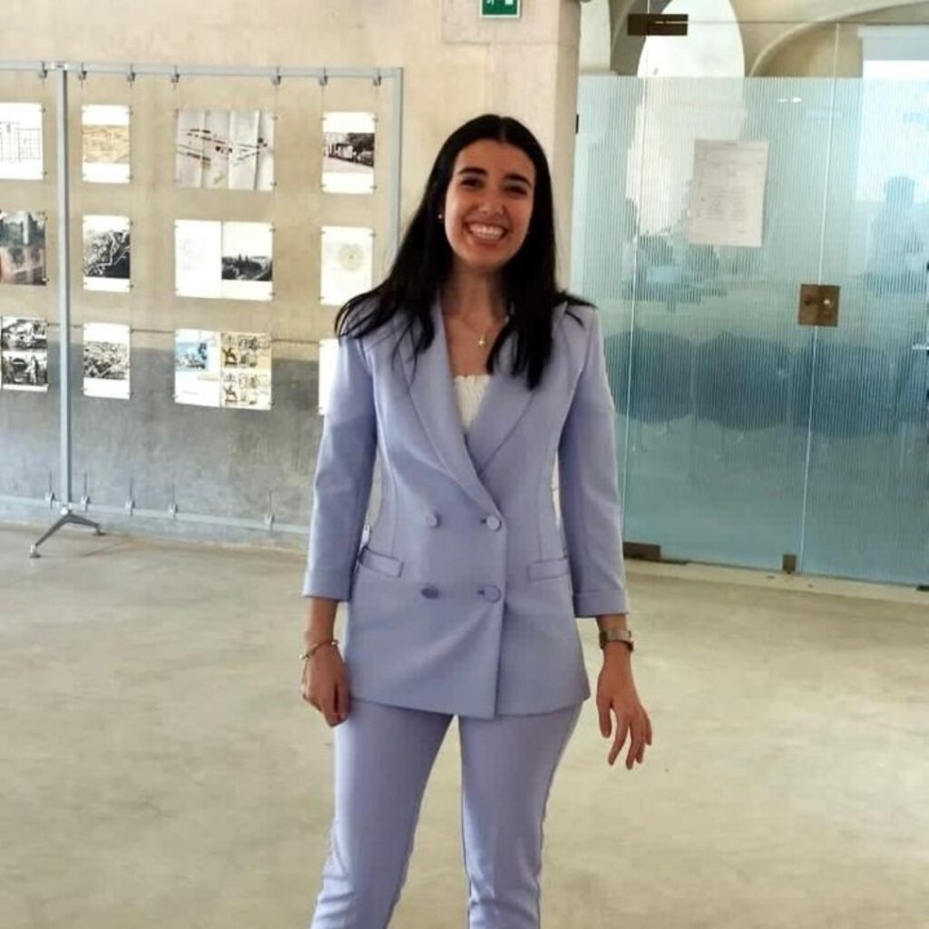 Camilla Pirrello posa in piedi sorridente nel giorno del conseguimento della laurea